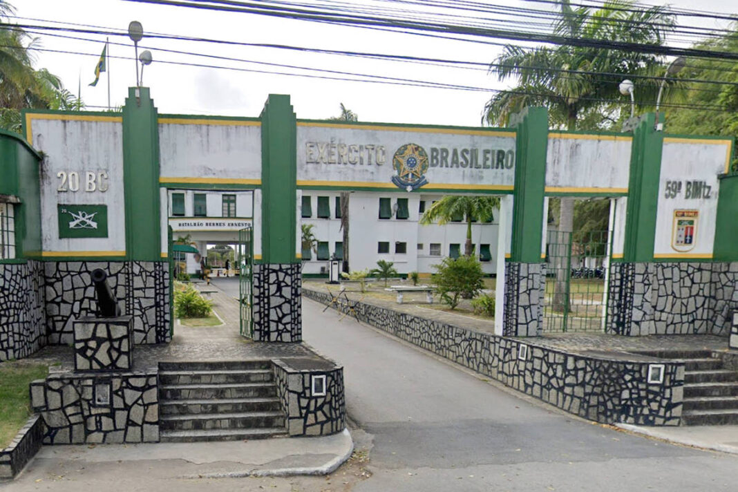 Portão de entrada do Exército Brasileiro com estrutura verde e branca, com inscrições 